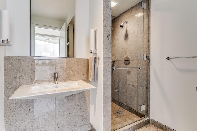 full bath featuring a shower stall, tasteful backsplash, and a sink