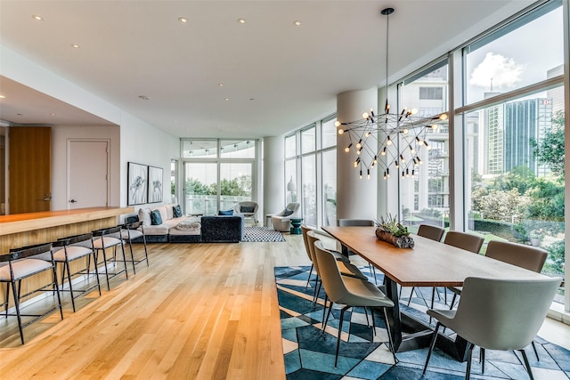 dining room with recessed lighting, floor to ceiling windows, light wood-style flooring, and an inviting chandelier