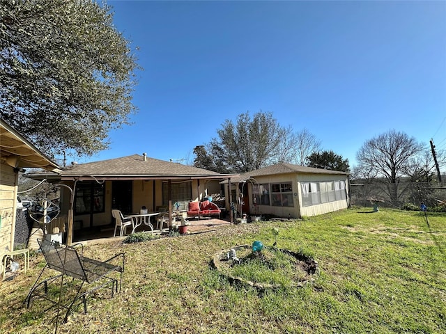 rear view of property with a yard and a patio area