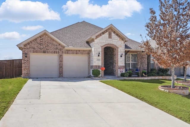 french provincial home with brick siding, fence, a front lawn, and roof with shingles