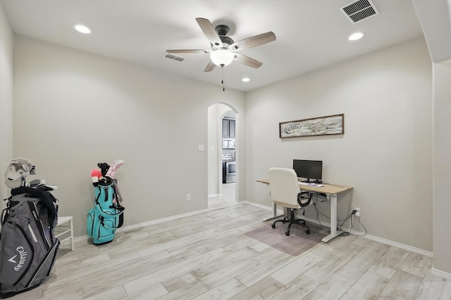 office area with arched walkways, visible vents, and wood finished floors