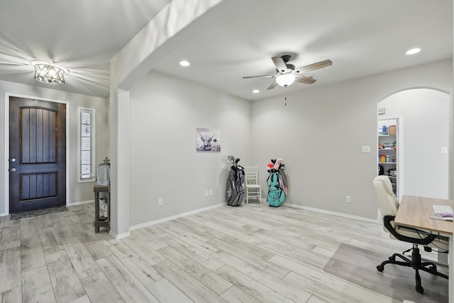 office with arched walkways, recessed lighting, baseboards, and wood finished floors