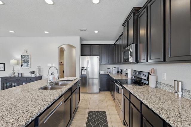 kitchen with visible vents, light stone counters, recessed lighting, appliances with stainless steel finishes, and a sink