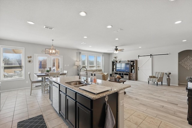 kitchen featuring visible vents, recessed lighting, a sink, a barn door, and open floor plan