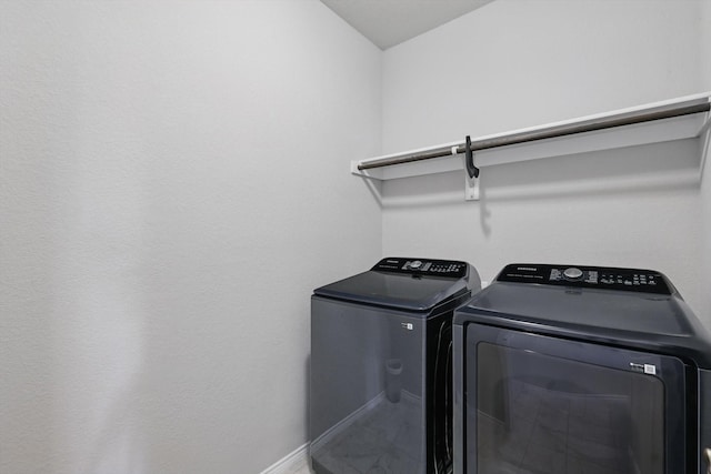 laundry room with laundry area, washer and dryer, and baseboards