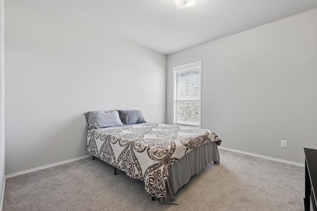 bedroom with light carpet and baseboards