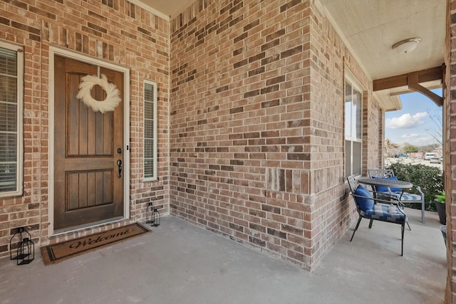 doorway to property featuring brick siding