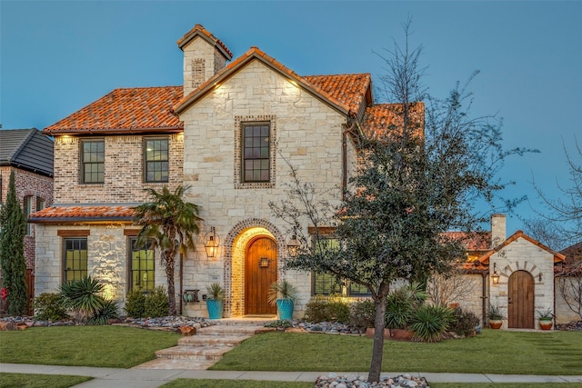 view of front facade with a tiled roof and a front yard