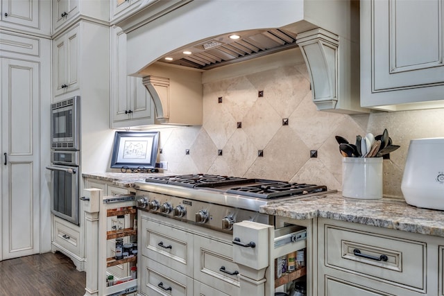 kitchen with premium range hood, tasteful backsplash, stainless steel appliances, arched walkways, and light stone countertops