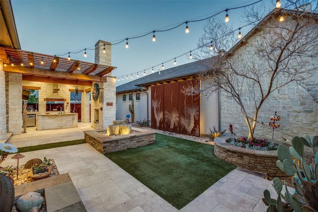 view of yard featuring a patio, exterior kitchen, and a pergola