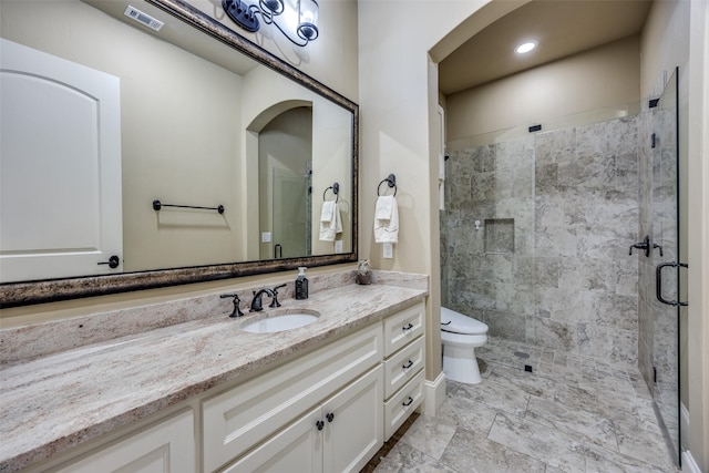 full bathroom with visible vents, toilet, a stall shower, and vanity