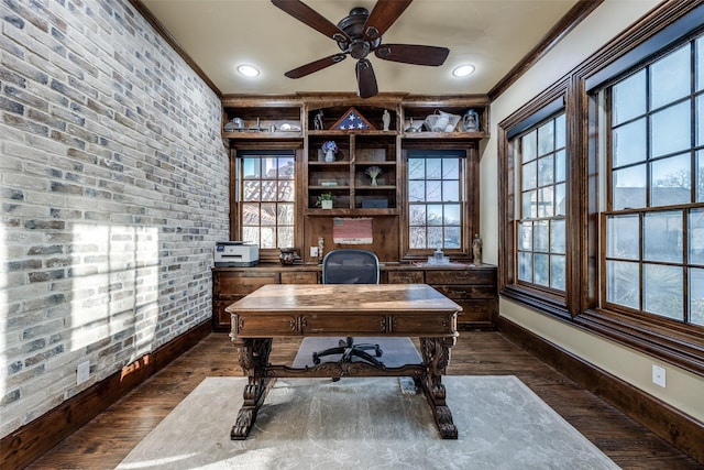 home office featuring dark wood finished floors, brick wall, baseboards, and ornamental molding