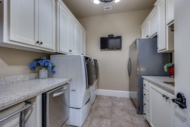 laundry area featuring visible vents, baseboards, and washing machine and dryer