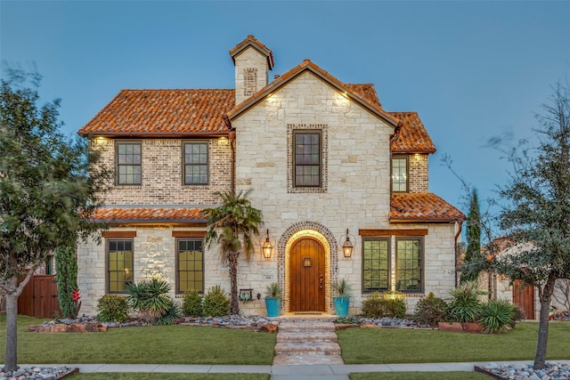 view of front of home featuring a tile roof, a front yard, and fence