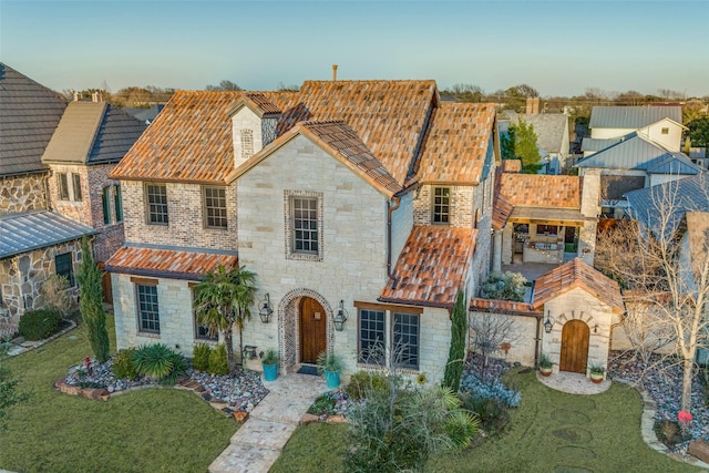 view of front of house with stone siding and a front lawn