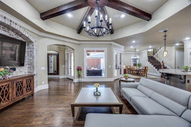 living area featuring wood finished floors, beamed ceiling, arched walkways, and a chandelier