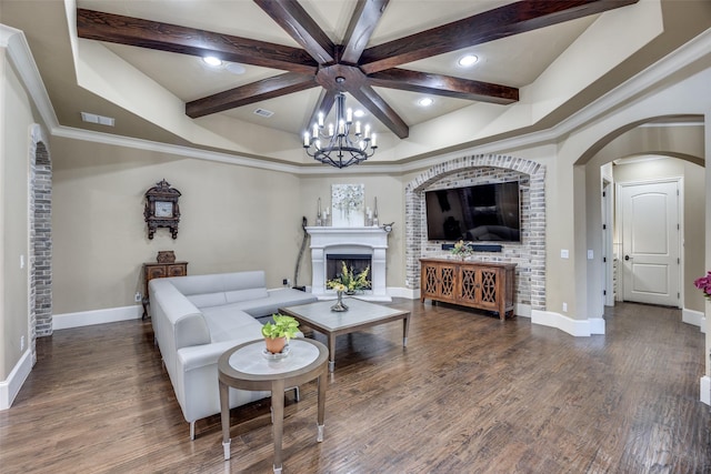 living area with wood finished floors, visible vents, arched walkways, and a fireplace with raised hearth