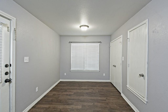 entrance foyer with dark wood-type flooring and baseboards