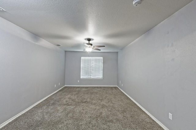 carpeted empty room featuring a textured ceiling, baseboards, visible vents, and ceiling fan