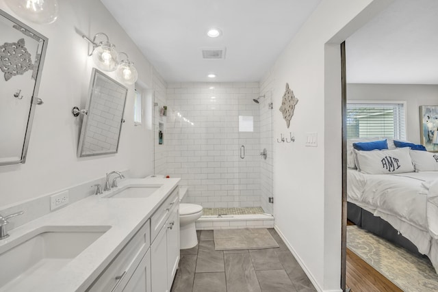 bathroom with a sink, toilet, a stall shower, and ensuite bathroom