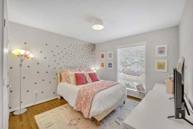 bedroom featuring light wood finished floors and baseboards