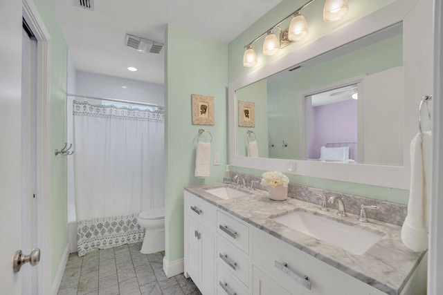 bathroom with double vanity, visible vents, toilet, and a sink