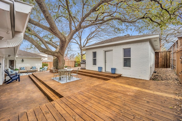 wooden terrace with outdoor dining space, an outdoor living space, and a fenced backyard