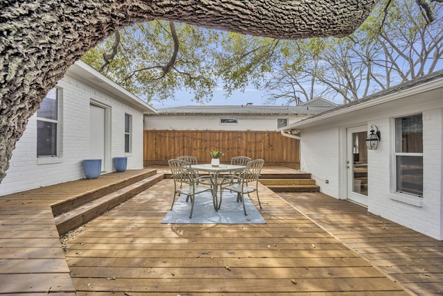 wooden deck with outdoor dining area and fence