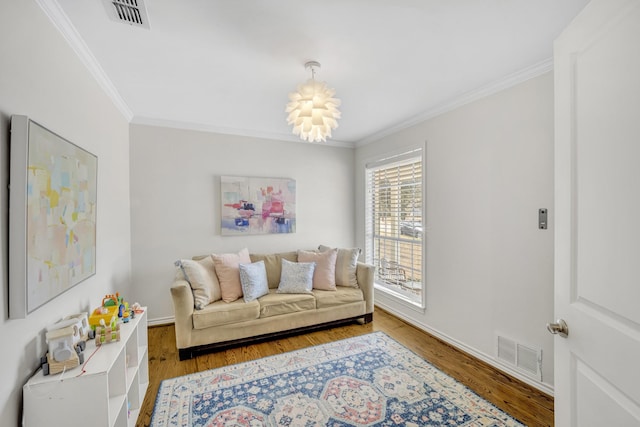 living room with visible vents, wood finished floors, and crown molding