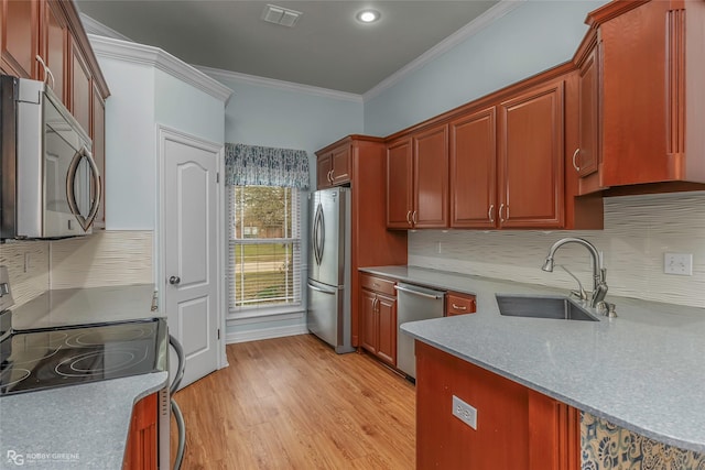 kitchen featuring visible vents, light wood-style flooring, a sink, appliances with stainless steel finishes, and crown molding