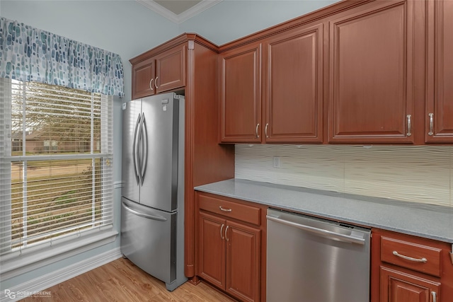 kitchen with brown cabinetry, light wood-style flooring, appliances with stainless steel finishes, and crown molding