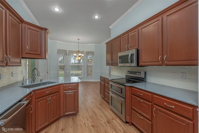 kitchen featuring a notable chandelier, a sink, stainless steel appliances, light wood-style floors, and crown molding