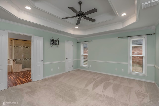 unfurnished bedroom with visible vents, a raised ceiling, carpet floors, and crown molding