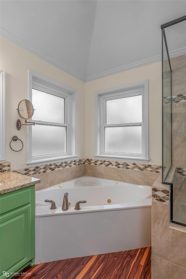 full bathroom with vanity, vaulted ceiling, a tile shower, and a whirlpool tub