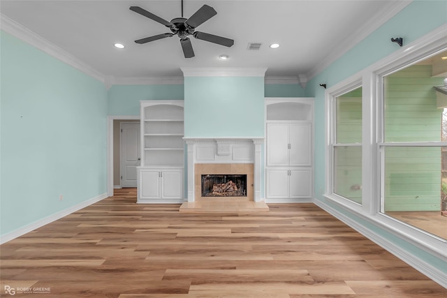 unfurnished living room with baseboards, a fireplace, visible vents, and ornamental molding