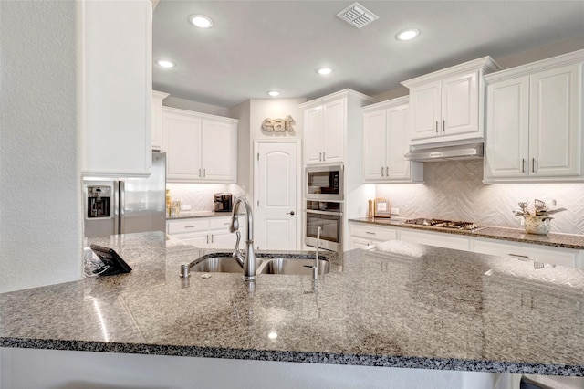 kitchen featuring visible vents, under cabinet range hood, appliances with stainless steel finishes, white cabinets, and a sink