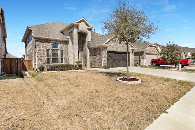 view of front of house with brick siding, fence, concrete driveway, roof with shingles, and a garage