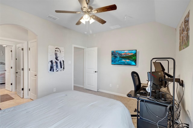 bedroom featuring visible vents, ceiling fan, lofted ceiling, light carpet, and arched walkways