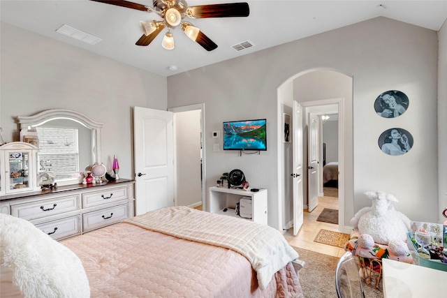 bedroom with arched walkways, visible vents, a ceiling fan, and vaulted ceiling