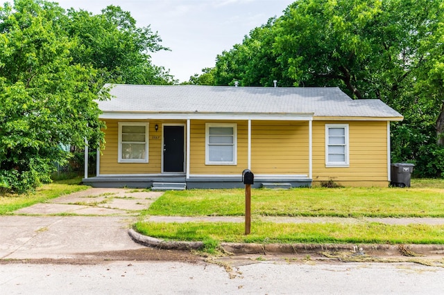 view of front facade featuring covered porch and a front lawn