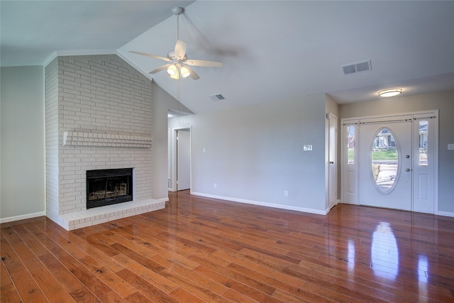 unfurnished living room featuring visible vents, wood finished floors, a fireplace, and a ceiling fan