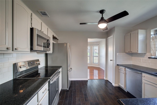 kitchen with dark wood-style floors, baseboards, visible vents, stainless steel appliances, and decorative backsplash