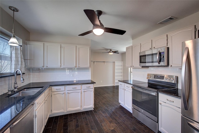 kitchen featuring visible vents, dark wood finished floors, a sink, appliances with stainless steel finishes, and white cabinetry