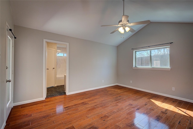 unfurnished bedroom with connected bathroom, baseboards, lofted ceiling, and hardwood / wood-style flooring