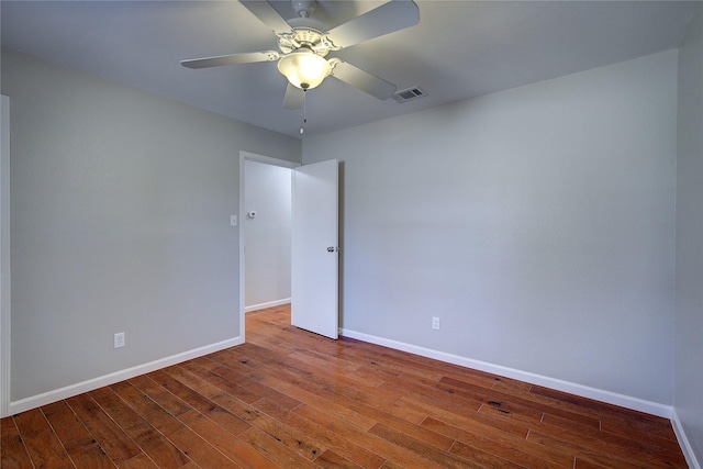 unfurnished room featuring a ceiling fan, baseboards, visible vents, and wood-type flooring