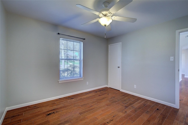 unfurnished room with ceiling fan, baseboards, and hardwood / wood-style flooring