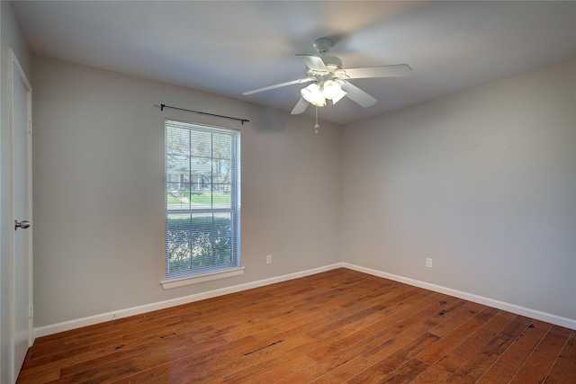 empty room with baseboards, wood finished floors, and a ceiling fan