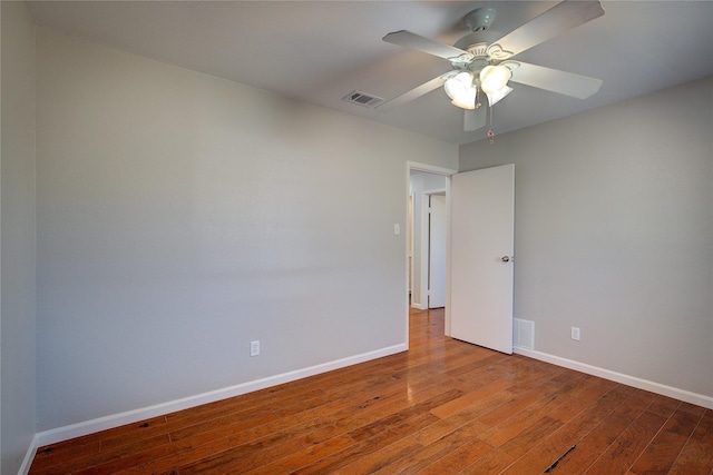 empty room featuring visible vents, wood-type flooring, baseboards, and a ceiling fan