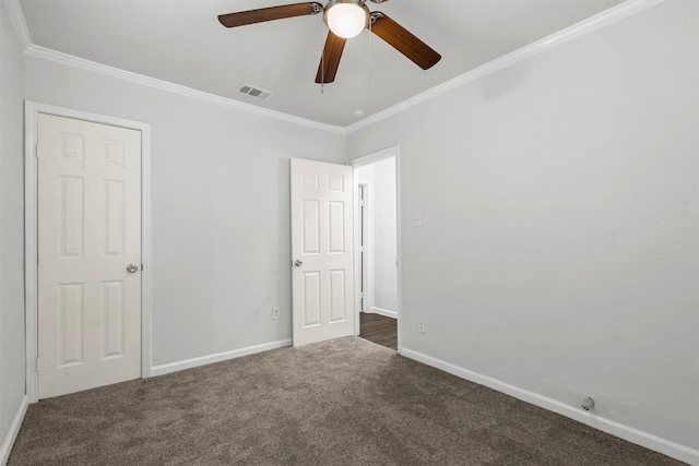 unfurnished bedroom featuring baseboards, visible vents, carpet floors, and ornamental molding