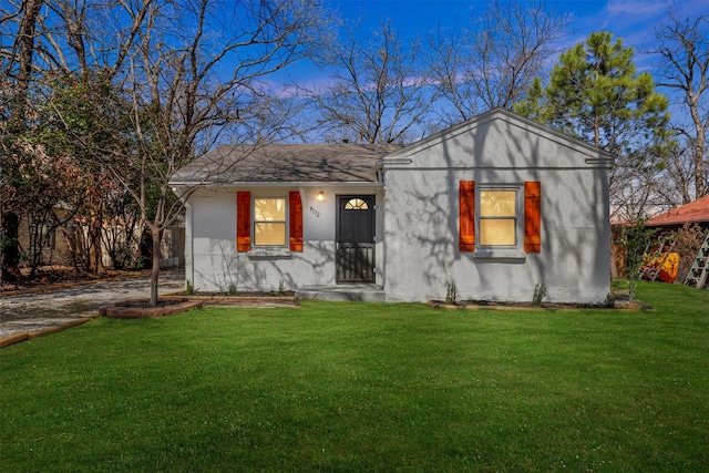 view of front of property featuring a front lawn and stucco siding